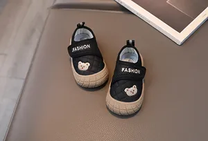 Detail view of black toddler shoes with bear embroidery and protective beige rubber toe caps