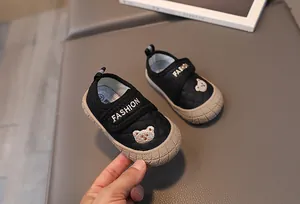 Detail of children's anti-slip shoes showing quilted fabric and cute bear embroidery