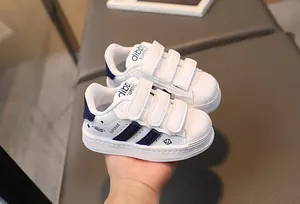 Close-up of kids' shell-toe sneakers with triple hook-and-loop straps and star patterns