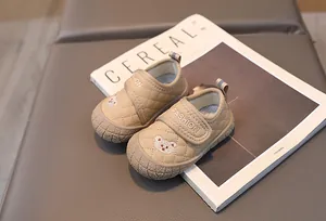 Detail of beige quilted toddler shoes with bear embroidery and hook-and-loop strap