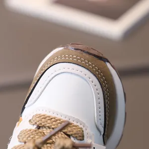 Kids retro running shoes with white leather, brown suede toe, and khaki woven laces