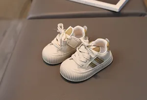 Detailed view of cream and mustard toddler walking shoes with protective toe caps