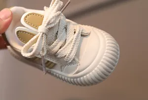 Close-up of soft cream baby sneakers with cute rabbit ears and anti-slip rubber soles