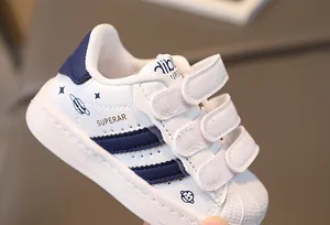 Detail view of shell-toe kids' sneakers with navy stripes and space pattern motifs