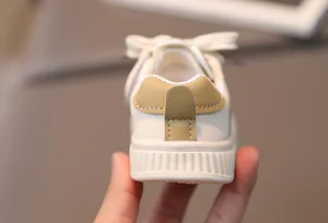 Close-up of the heel detail on beige toddler sneakers with premium khaki leather patchwork