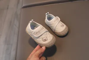 Detailed close-up of quilted toddler walking shoes with bear embroidery and Velcro strap