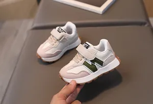 Detailsicht der Kindersportschuhe mit rosa Besatz und grünem M-Muster Design