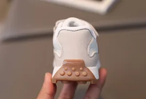 Detail eines Retro-Kindersneakers mit brauner Gummisohle und rutschfesten Fersennoppen