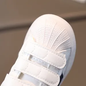 Classic white kids shell-toe sneakers with dual velcro straps and durable synthetic leather