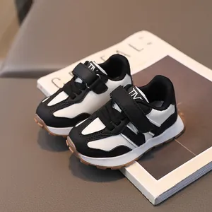 Klassische schwarz-weiße Kindersneaker mit Klettverschluss und rutschfester Sohle