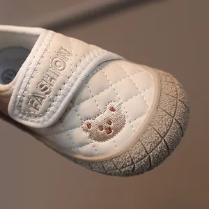 Creamy beige toddler shoes with quilted design and bear embroidery on the front