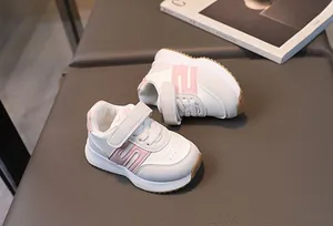 Détail de baskets pour enfants blanches et roses avec scratch et semelle antidérapante