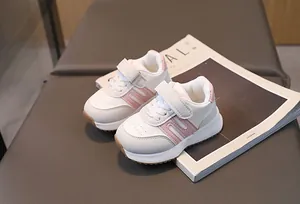 Vue détaillée de la chaussure de sport pour bébé rose avec scratch et motif d'étoile