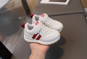 Detail of white toddler sneakers featuring red stripes and durable non-slip rubber soles