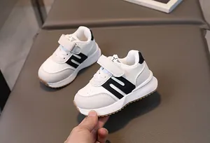 Vue détaillée des baskets blanches pour enfants avec logo N noir et bande auto-agrippante