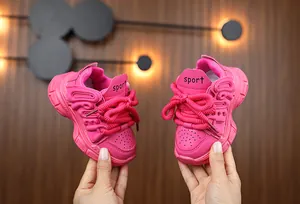 Detail of pink girls sports sneaker with thick laces and embossed lettering decor