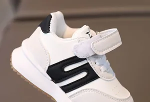 Détail de chaussure de sport pour bébé avec étoile noire et fermeture à scratch pratique