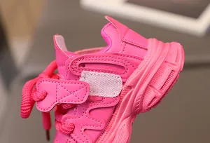 Detail of pink girls' sneaker featuring secure velcro strap and textured thick sole unit