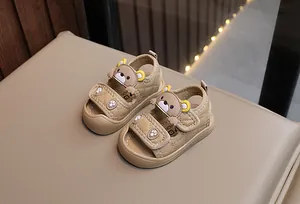 Detail view of khaki toddler sandals with cartoon bear design and velcro closure strap