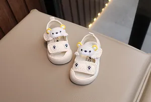 Close-up of baby sandals featuring a 3D cartoon bear and velcro strap detail
