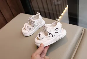 Gros plan de sandales bébé crème avec texture matelassée et motif panda mignon