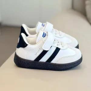 Minimalist kids retro sneakers in black and white leather with convenient velcro closure