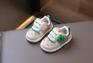 Dettaglio scarpe da primi passi beige con motivo a orsetto e chiusure a strappo verdi