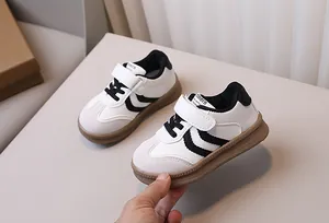 Detail of kids' black and white sneakers with hook and loop closure and non-slip rubber sole