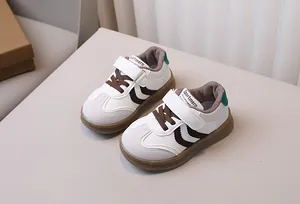 Close-up of children's white leather sneakers with brown V-stripes and rubber soles