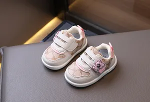 Dettaglio di scarpe per bambini con motivi di orsetto e doppia chiusura a strappo