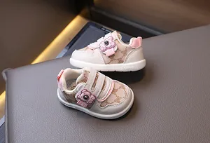 Dettaglio di scarpe per neonati rosa con orsetto 3D e suola morbida antiscivolo di qualità