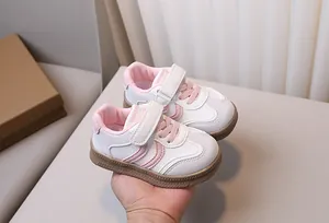 Detail of pink and white toddler sneakers with velcro straps and non-slip rubber soles