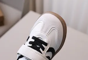 Close-up of children's sneaker with white leather, grey suede and non-slip gum sole