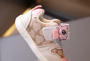 Dettaglio scarpa primi passi per bambini con motivo orsetto beige e chiusura velcro