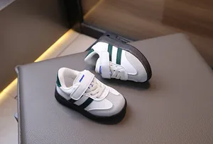 Detail of toddler sneakers with green stripes, Velcro strap and durable rubber sole