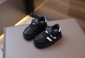 Top-down view of black toddler sneakers with white stripes and velcro strap closure