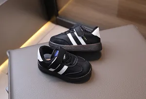 Close-up of black toddler sneakers with white stripes and easy velcro closure design