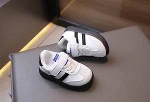 Detail view of toddler sneakers with black stripes and convenient velcro strap closure