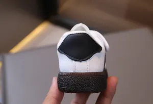 Close-up of baby sneaker heel showing black leather patchwork and durable gum sole