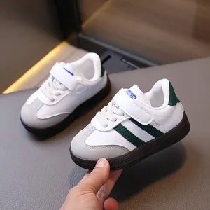 Kids retro sports sneaker in white and dark green with velcro closure and rubber sole