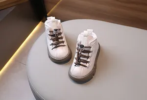Dettaglio di stivali da neve per bambini in pelle crema con suole marroni antiscivolo