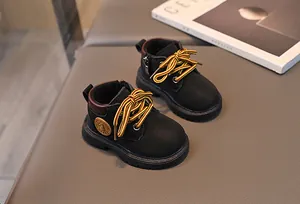 Detail von schwarzen Kinder-Combat-Boots mit gelben Schnürsenkeln und Reißverschluss