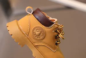 Nahaufnahme gelber Babystiefel mit dicker rutschfester Sohle und feinen Nähten