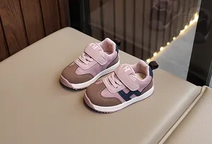 Dettaglio di scarpe rosa per neonati con chiusura a strappo e suola antiscivolo