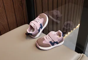 Dettaglio di scarpe per bambini rosa e blu navy con velcro e suole bianche antiscivolo
