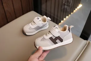 Dettagli di sneakers per neonati con chiusura in velcro e cuciture a contrasto e logo H