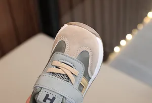 Dettaglio di sneakers per neonati con rete traspirante e chiusura a strappo in kaki e verde