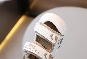 Detail of baby sandal featuring protective toe cap and bear paw design with velcro strap