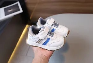Detail of white toddler sneakers with blue stripes and smiley face pattern