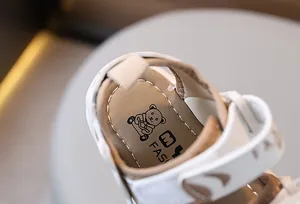 Detail of baby sandal showing cartoon bear insole and soft synthetic leather texture